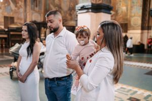Family gathered inside ornate church during religious ceremony.