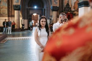 Church interior with attendees in white clothing during an Orthodox religious ceremony.