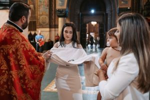 Attendees participate in an Orthodox church ceremony beneath ornate frescoed ceilings.