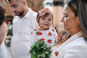Family gathering during religious ceremony with flowers and decorative elements.