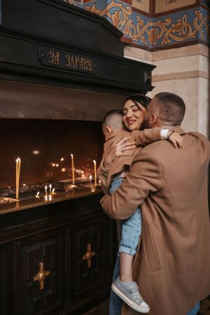 Candlelit church ceremony with intimate moments against dark wood paneling.