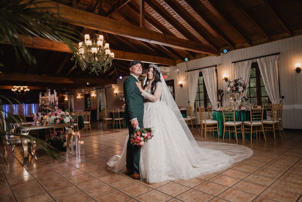 A romantic evening dance in an elegant reception hall with chandeliers, wooden beams, and tiled floors.