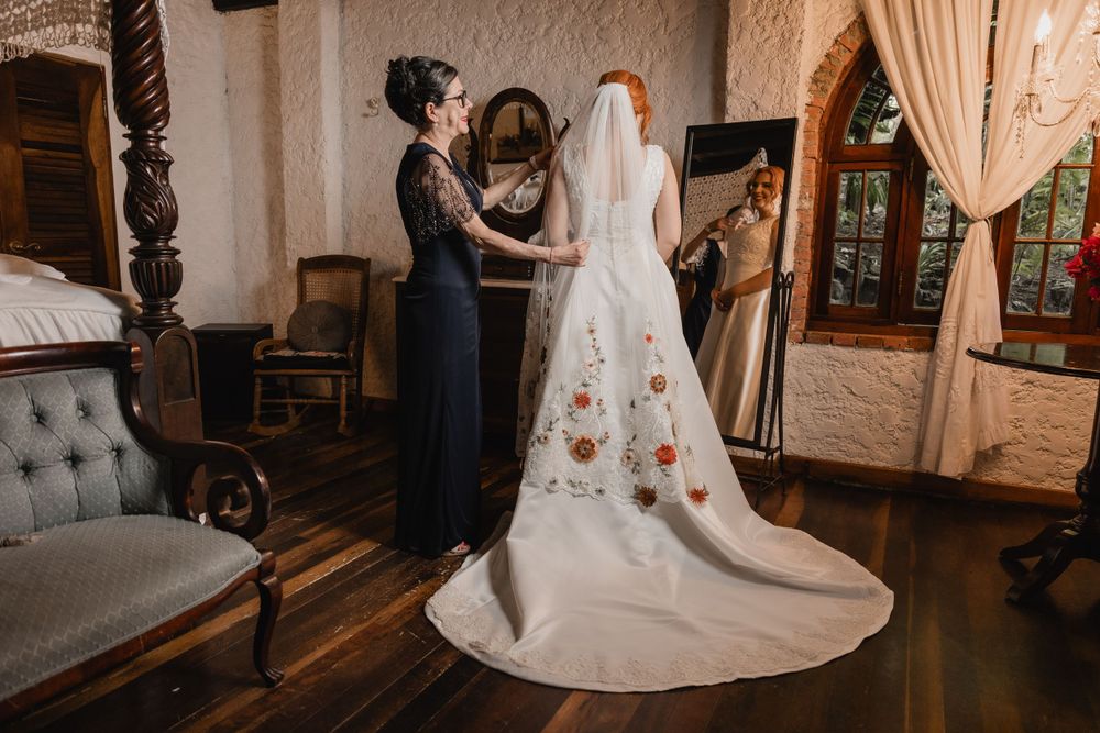 A wedding dress fitting in an elegant vintage room with ornate mirrors and plush furniture.