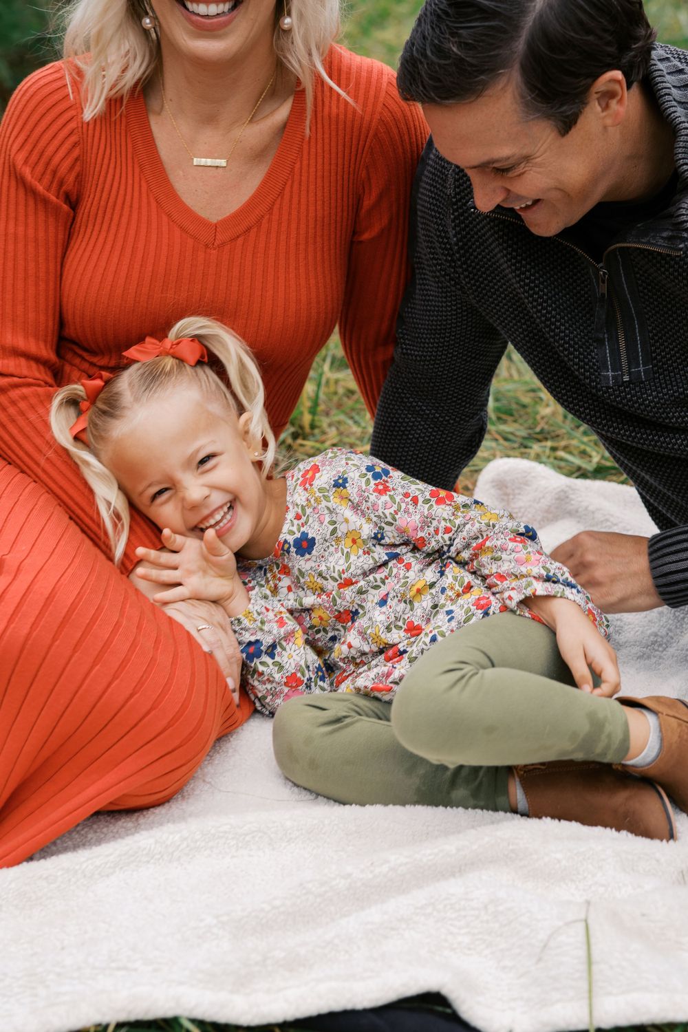 Candid family moments on white blanket at Christmas tree farm.