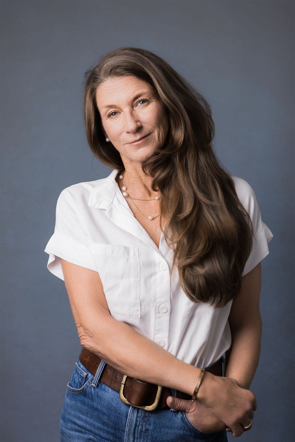 Studio portrait series showing casual styling with white button-down shirt and denim in various poses against gray backdrop.