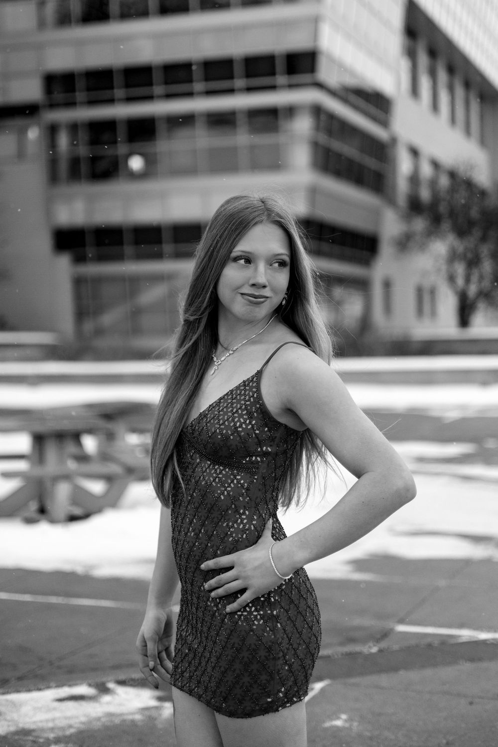 A series of five black and white portraits showing poses in an urban setting with cars and buildings visible.