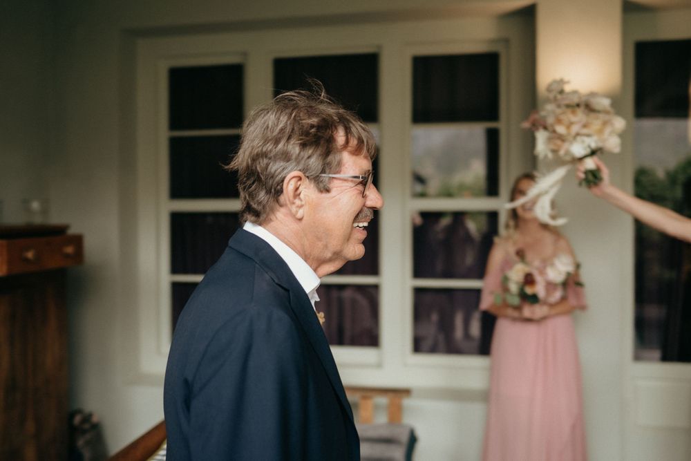 A formal indoor wedding moment captured with soft lighting and pink accents.