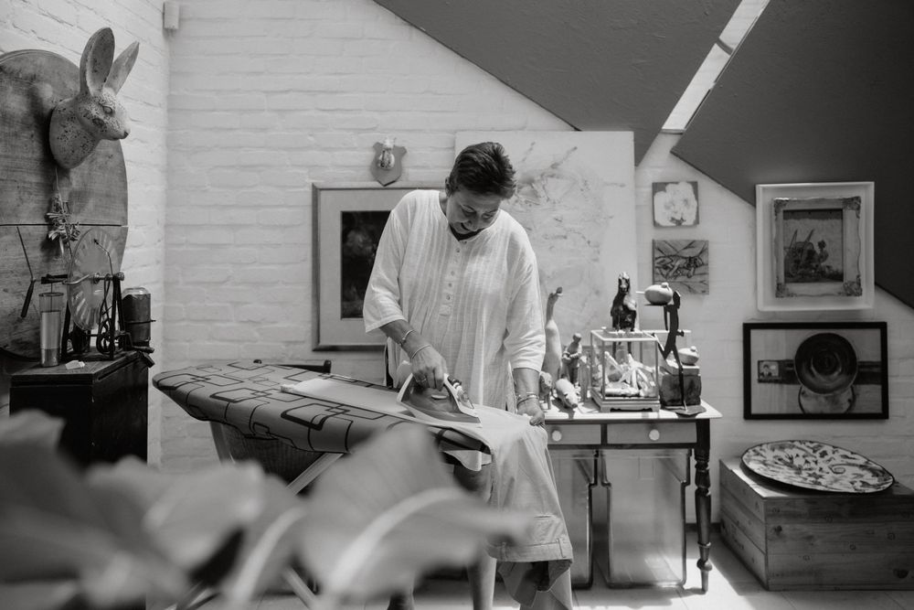 Black and white photo of food preparation in rustic kitchen setting.