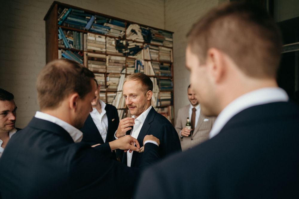 Group of groomsmen share a moment while getting ready before the ceremony.