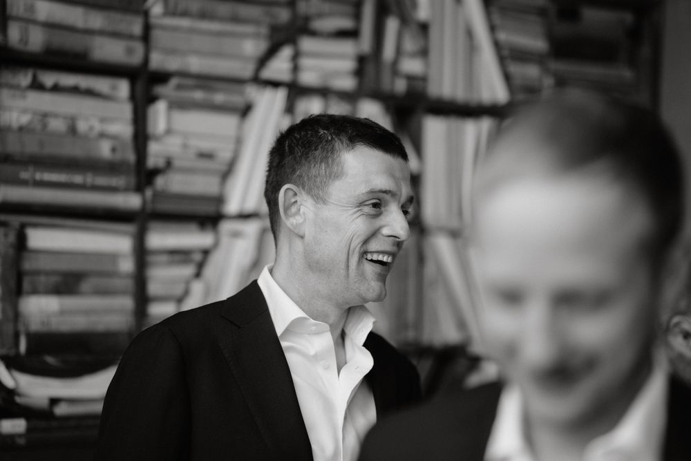 A black and white candid photo showing laughter and joy in front of a bookshelf.