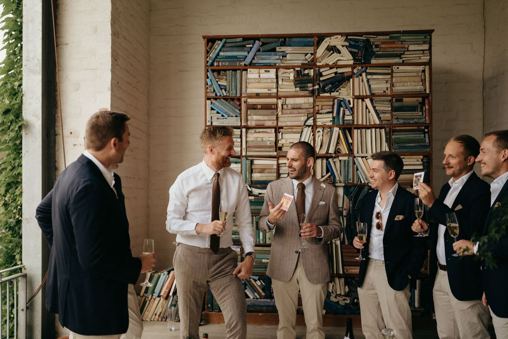Groomsmen gather on a porch for pre-wedding drinks and conversation.
