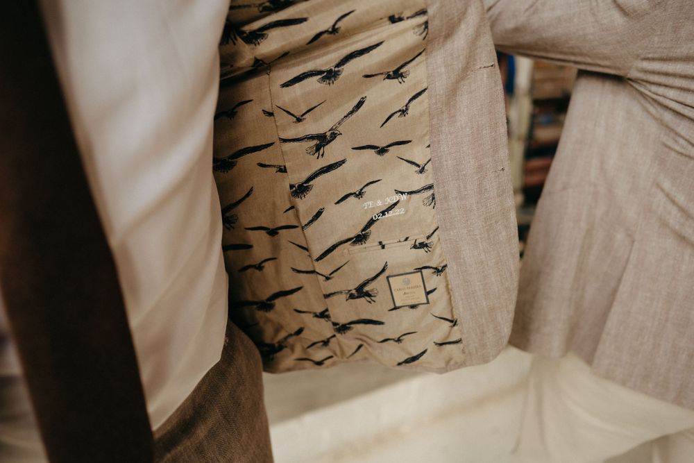 Abstract pattern of black bird silhouettes on beige fabric or textile surface.