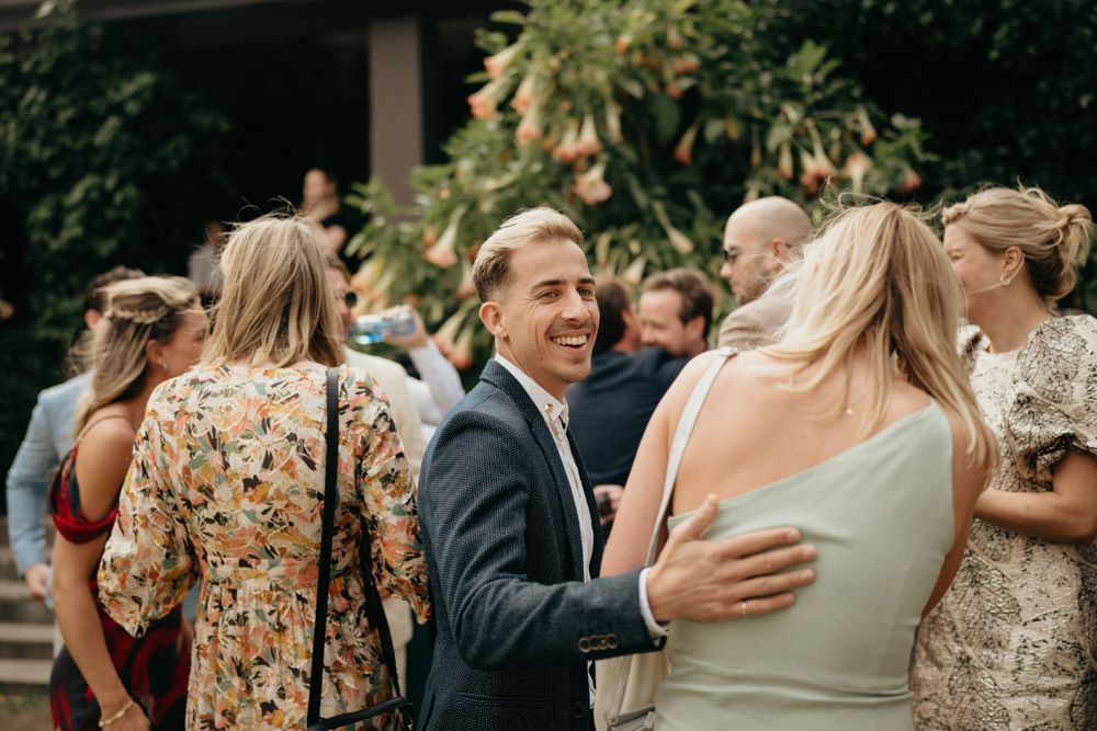Wedding guests mingle and celebrate during an outdoor garden reception.