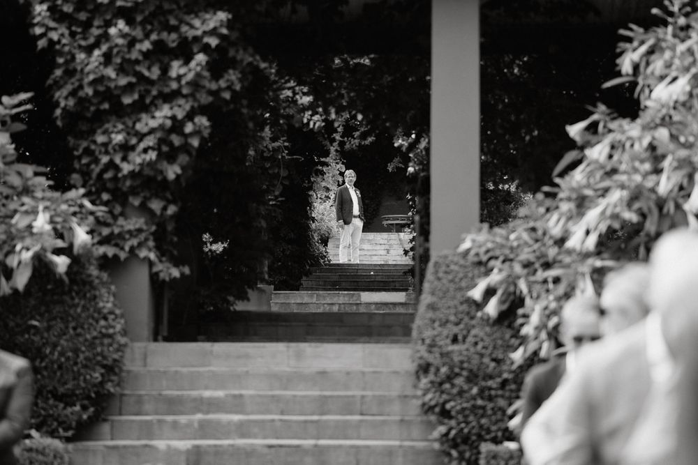 Black and white photo of stone steps framed by lush garden greenery at a wedding venue.