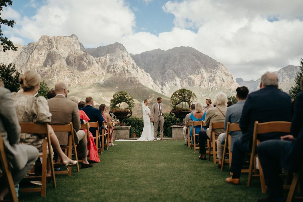 Outdoor wedding ceremony setup with mountain backdrop in a scenic natural setting.