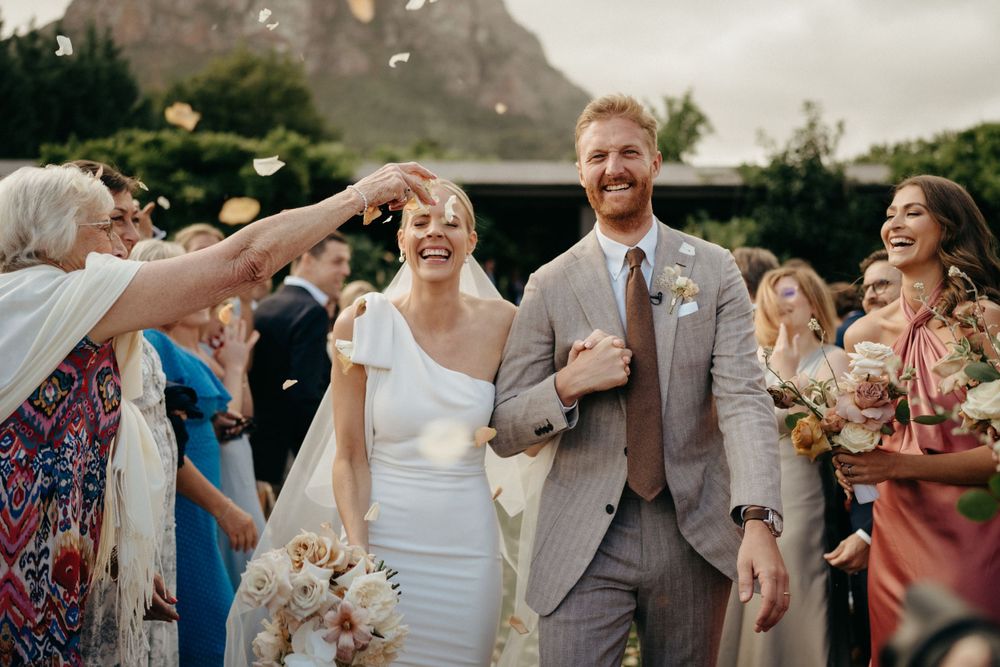 Celebratory moment at outdoor wedding with guests throwing confetti.