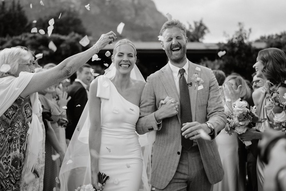 Wedding celebration with confetti being thrown during an outdoor ceremony.