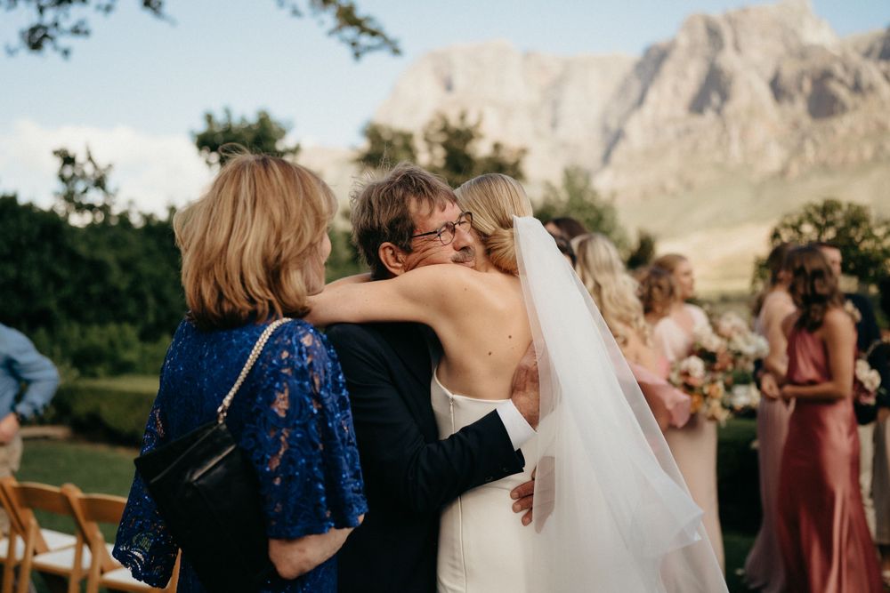 Emotional embrace during outdoor mountain wedding ceremony with scenic backdrop.