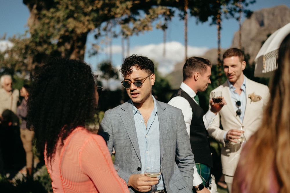 Guests enjoying drinks and conversation at an outdoor wedding reception.