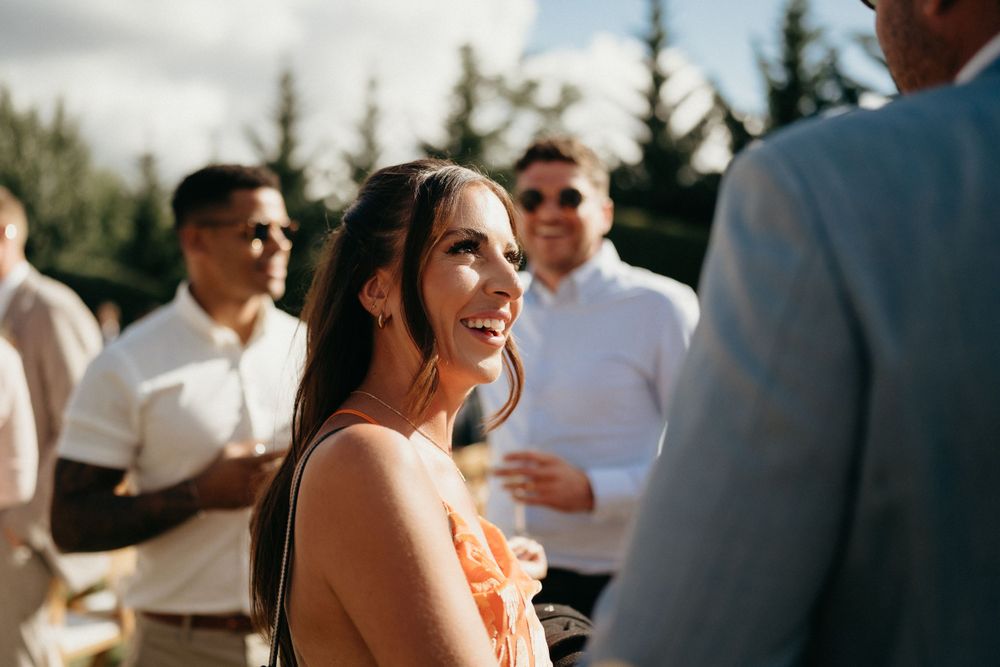 Candid moment during outdoor cocktail reception with mountain scenery.