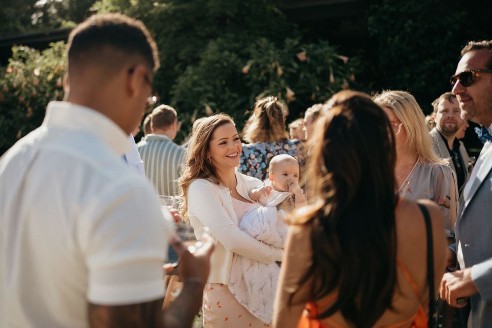 Outdoor garden party guests mingling and socializing at a daytime celebration.