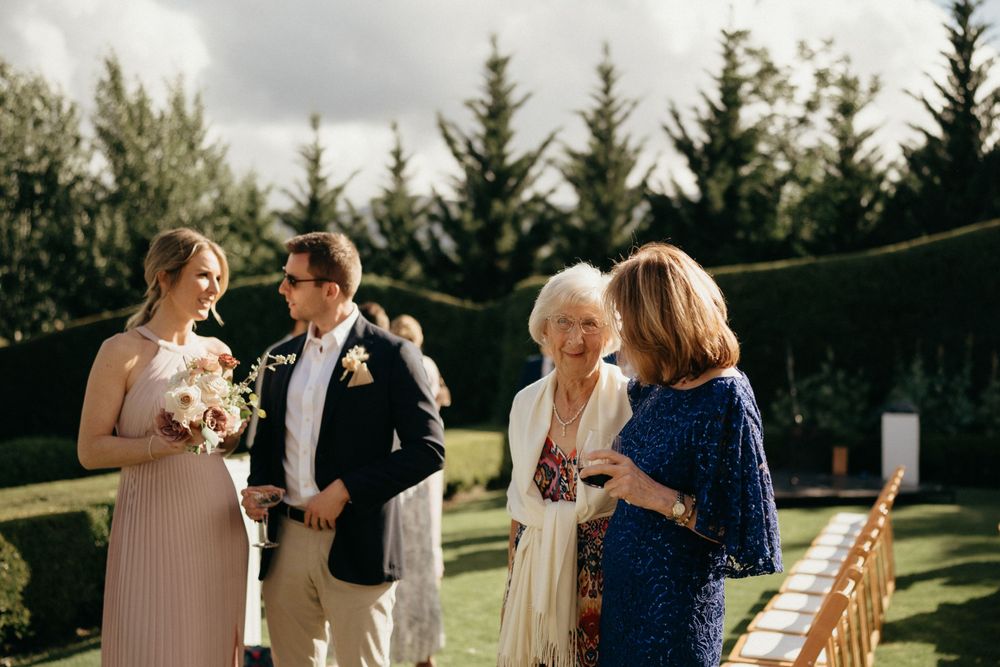 Wedding guests gathered on a manicured lawn for an outdoor celebration.