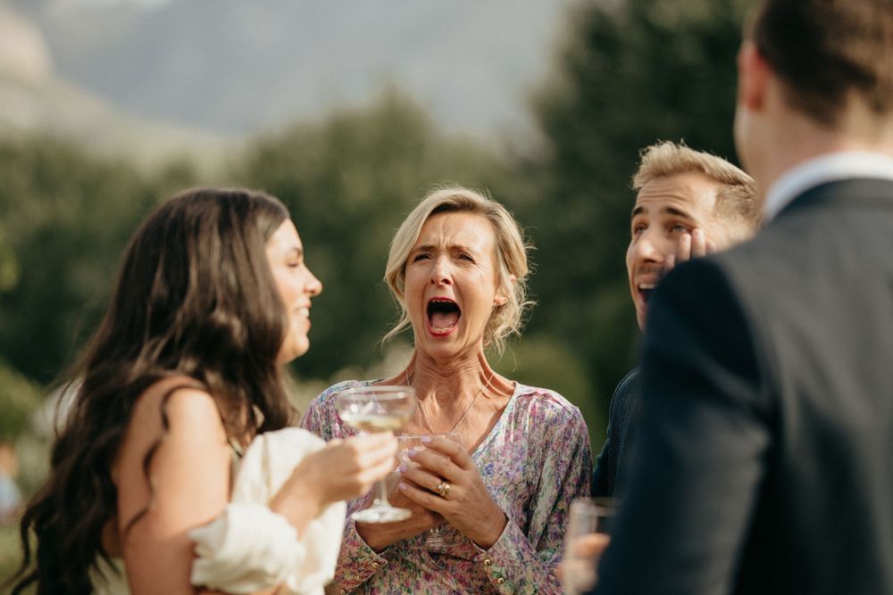Candid moment of laughter and celebration during an outdoor wedding reception.