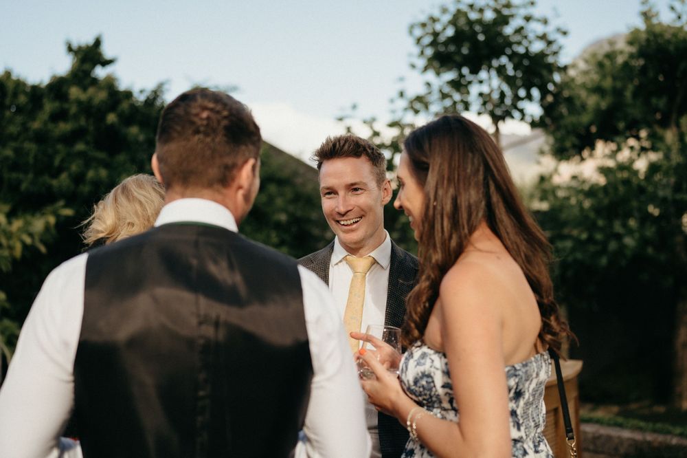 Wedding guests enjoying conversation during an outdoor celebration.
