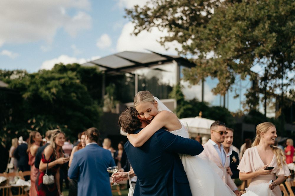 An emotional embrace on an outdoor dance floor surrounded by wedding guests.