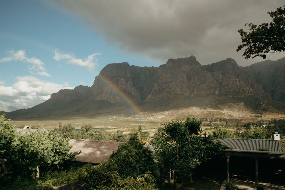 Dramatic mountain landscape with cloudy skies and rocky peaks in the background.