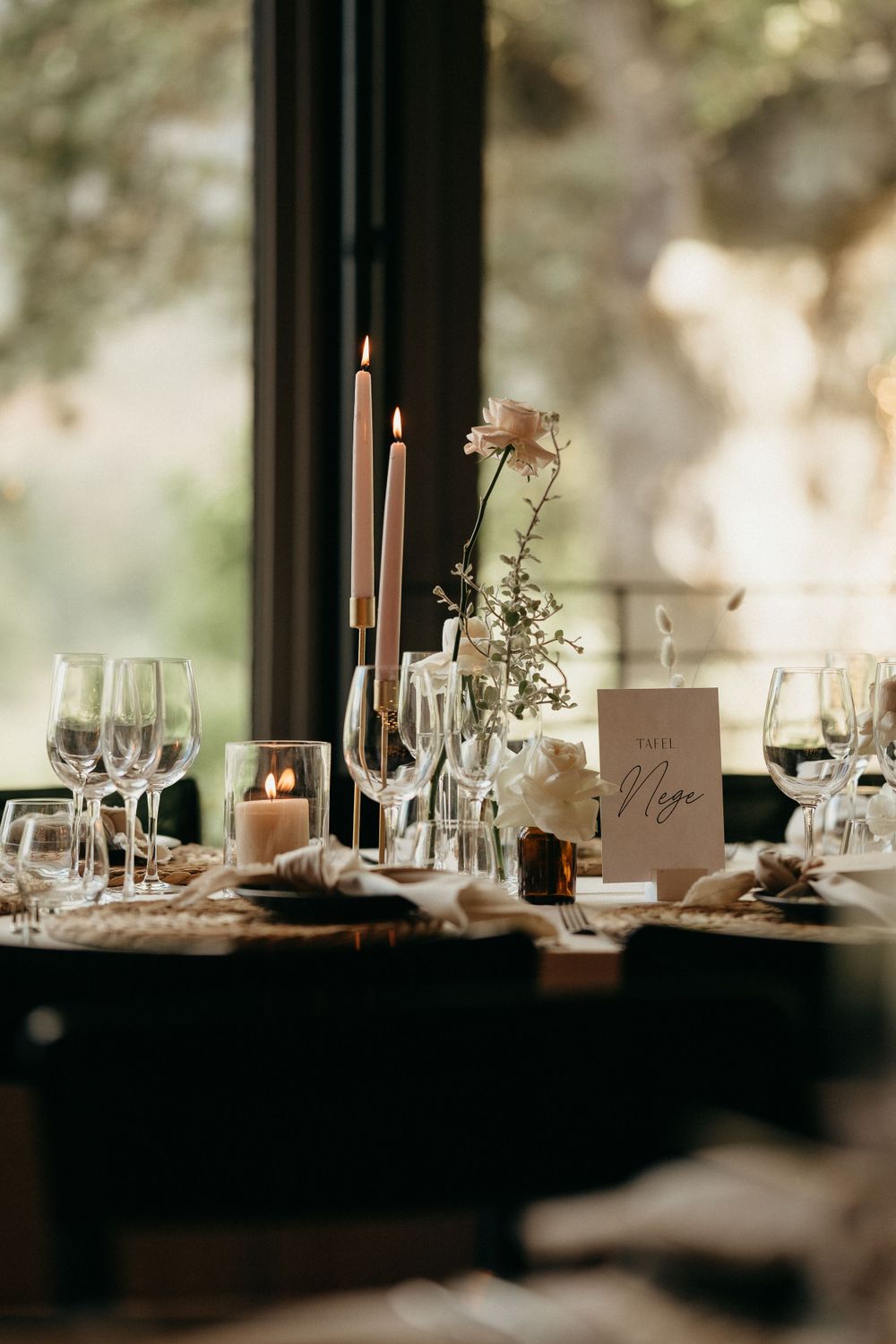 Elegant wedding table setting with candles, glassware and delicate floral centerpieces.