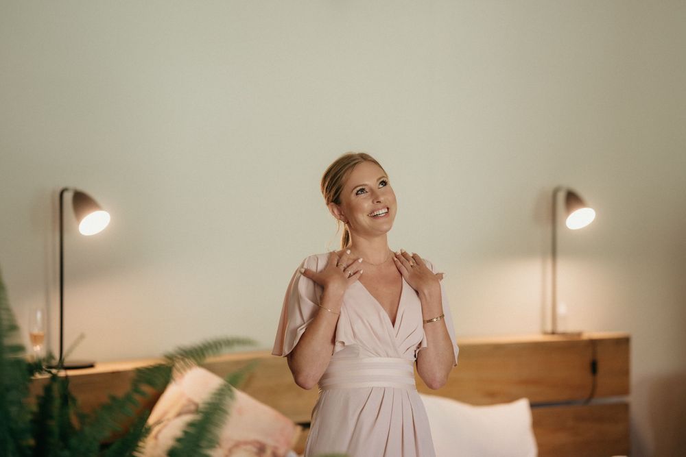 Getting ready scene with beautiful gown and soft lighting in bedroom setting.