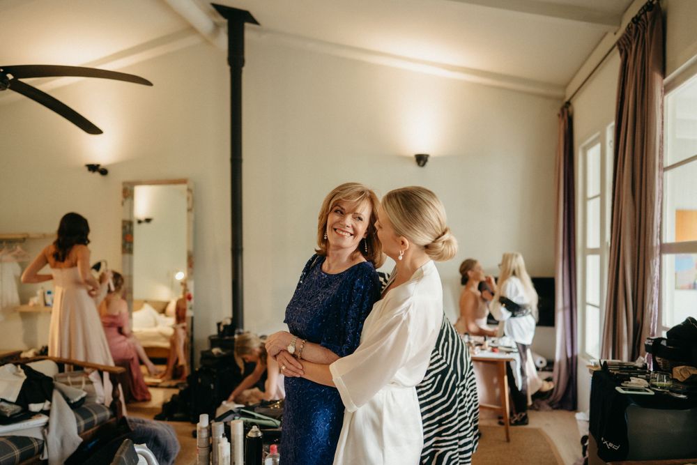 A bright getting-ready room shows wedding preparations underway with ceiling fans and natural lighting.