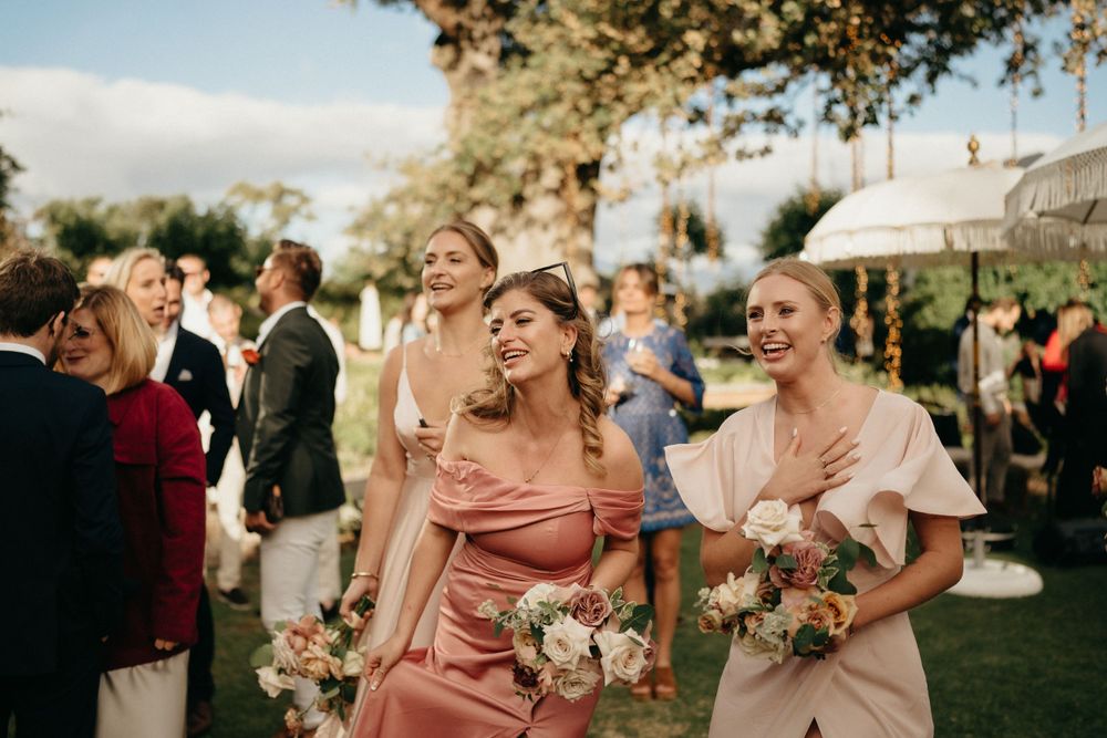 Wedding guests in pastel dresses enjoying an outdoor garden celebration.