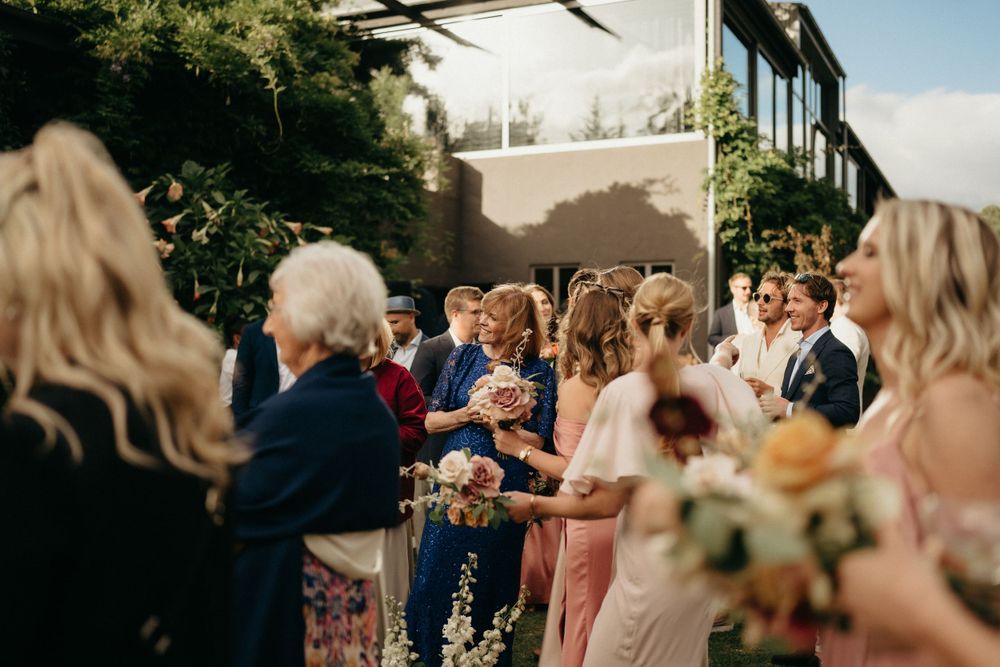 Wedding guests gathered outdoors for a sunny afternoon reception celebration.