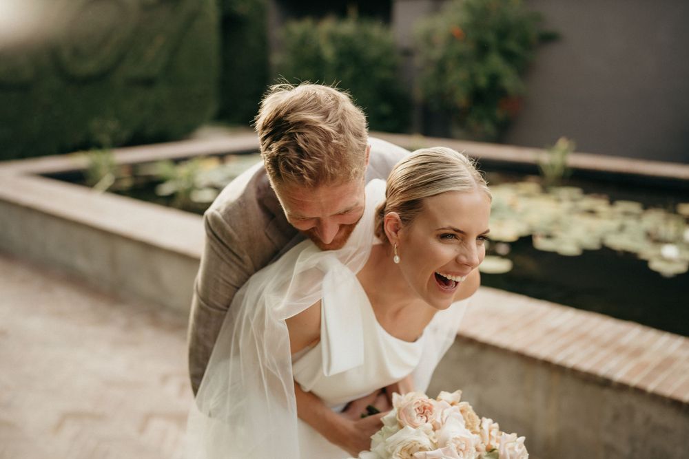 A joyful candid moment captured between newlyweds during their wedding celebration.