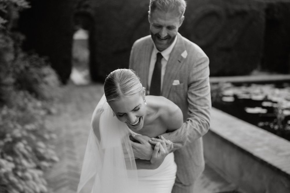 Black and white candid moment captured during outdoor wedding celebration.
