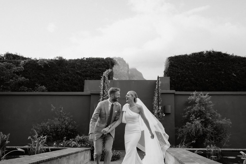 Black and white photo of wedding celebration with smoke effects and garden backdrop.
