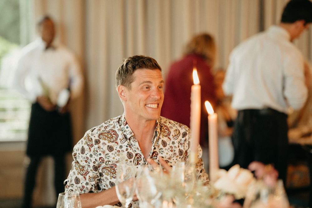 Guest enjoys dinner at an elegant wedding reception with candlelight and table settings.