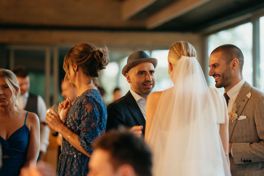 Wedding reception guests mingle and celebrate during an indoor evening celebration.