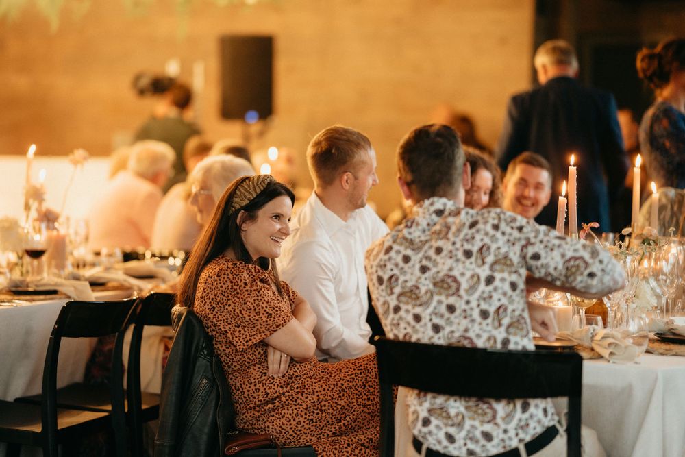 Warm candlelit wedding reception dinner with guests seated at elegant tables.