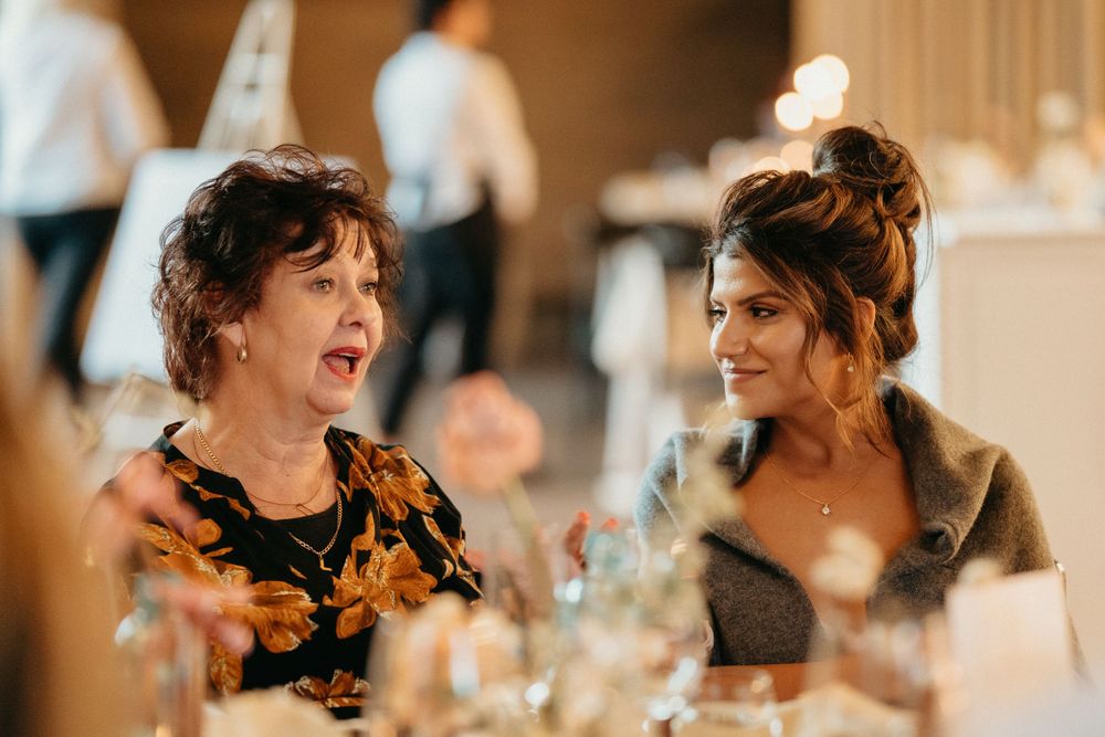 Guests enjoying animated conversation at an elegant wedding reception dinner.