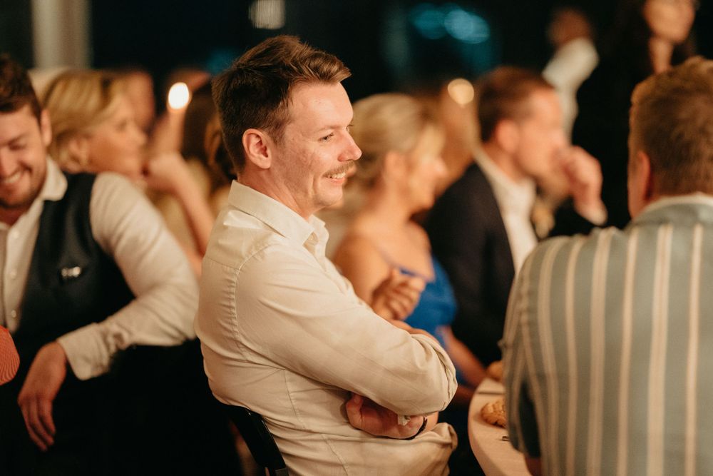 Wedding reception guests enjoying themselves during evening celebrations indoors.
