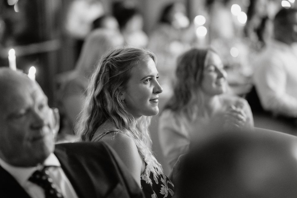 Black and white candid photo of guests during an elegant wedding reception dinner.