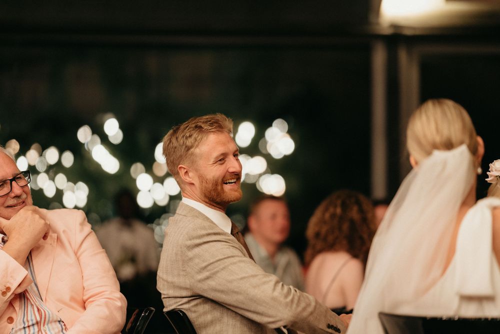 Wedding reception guests laughing and enjoying the celebration.