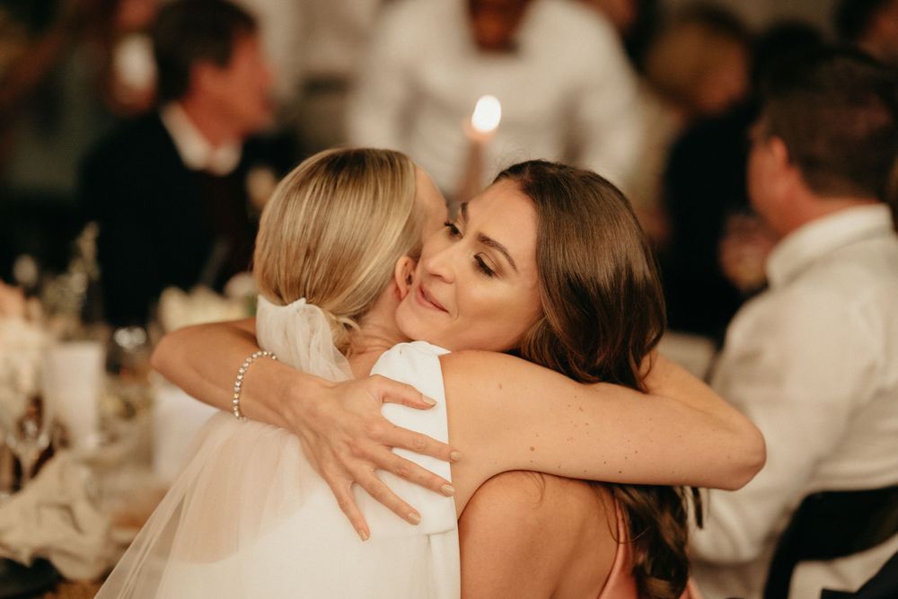 Emotional embrace shared during a dimly lit wedding reception.