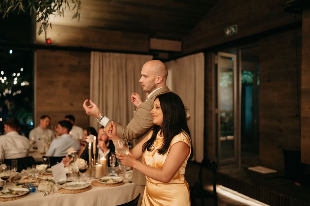 Wedding guests enthusiastically participating in dinner reception celebrations.