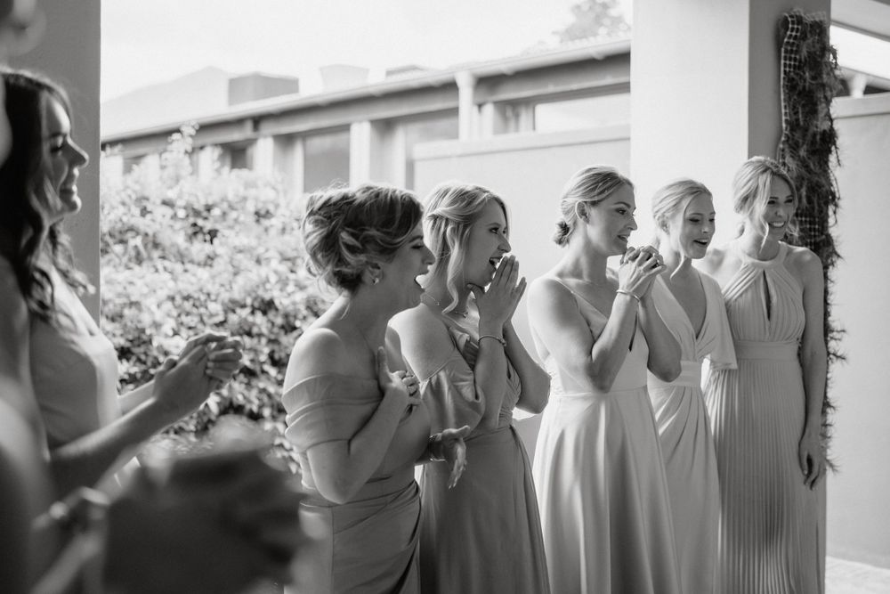 Wedding party members in elegant dresses share an emotional moment together.