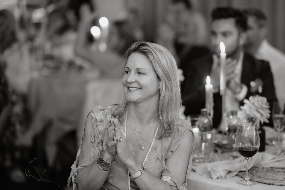 Black and white photo captures candid joy during an elegant candlelit reception.