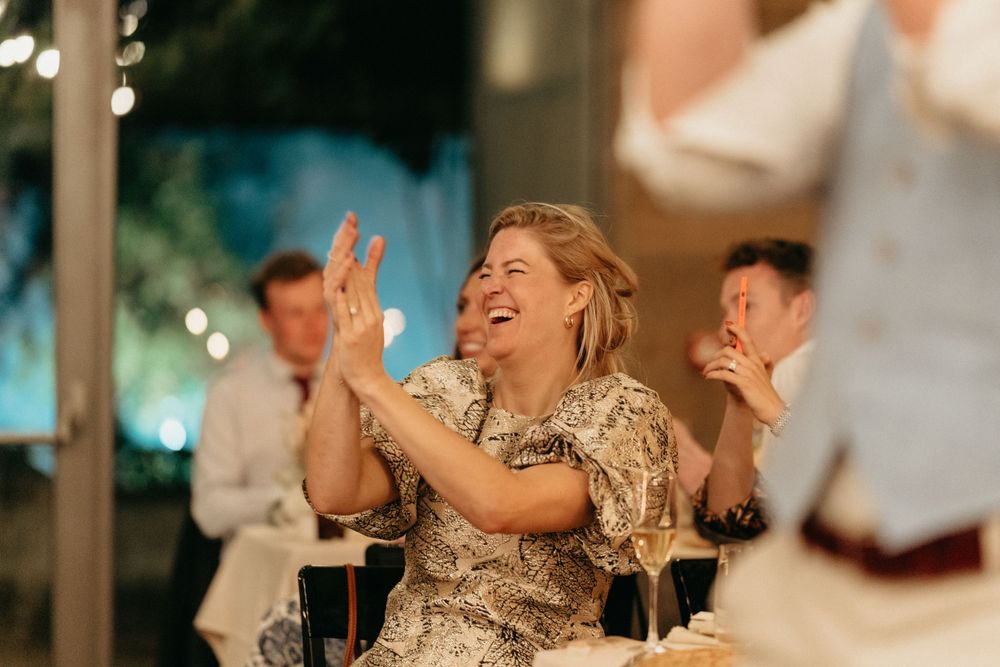 Wedding guest in sparkly dress enjoying the celebration with joyful laughter.